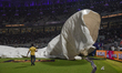 Ground staff pull rain covers amid a storm as rain interrupts the play during the 2025 IPL...