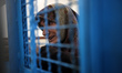 A Palestinian woman waits to receive a medication ration at the UNRWA-run clinic at al-Sha...