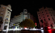 The lights of passing vehicles illuminate the buildings in Puerta Real Square during the p...