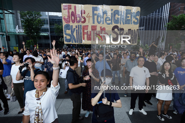 A lady holds up a placard during the Singapore Democratic Party's (SDP) lunchtime rally in the heart of the Central Business District at Boa...