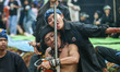 Two artists from the Satria Cakra Manglayang Foundation perform with a chainsaw on their t...