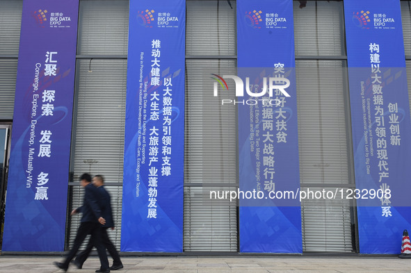 Visitors pass by scrolls for Guiyang International Big Data Expo 2016 in Guiyang, capital of southwest China's Guizhou Province, May 25, 201...