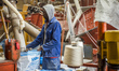 A worker of the Salt Factory packs salt into 50-kilograms  bags in Swakopmund, Namibia, on...