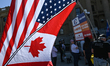 EDMONTON, CANADA - MAY 3:A participant holds a fabricated US/Canadian joined flag as Albe...