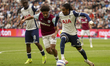 Jean-Clair Todibo of West Ham United and Djed Spence of Tottenham Hotspur battle for the b...