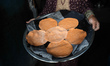 A Palestinian woman carries flatbread made with ground lentils during a flour shortage in...