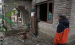People assess a damaged residential house in Uri town, Baramulla district, north of Srinag...
