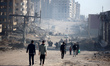 Palestinians walk along Al-Rasheed Street in western Gaza City during the hot weather in G...