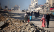 Palestinians walk along Al-Rasheed Street in western Gaza City during the hot weather in G...