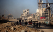 Palestinians walk along Al-Rasheed Street in western Gaza City during the hot weather in G...