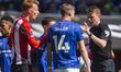 Jack Taylor of Ipswich Town and Sepp van den Berg of Brentford interact with Referee Sam B...