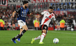 Manuel Lanzini of River Plate competes for the ball with Cristian Zabala of Independiente...