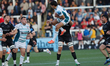 Santi Carreras of Gloucester Rugby takes a high ball under pressure from John Hawkins of N...
