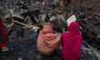 Slum dwellers search for their household belongings after a fire breaks out at a slum in t...