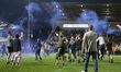 Oldham Athletic fans celebrate on the pitch at the final whistle during the Vanarama Natio...