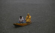 A man rows a boat on the waters of Dal Lake during heavy rainfall in Srinagar, Jammu and K...