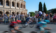 A general view shows the peloton competing with the Colosseum in Rome in the background du...
