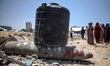 Palestinian children wait with others for food at a distribution point in Gaza City, on Ju...