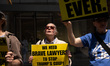Demonstrators hold signs and chant words of gratitude outside of law firms Jenner & Block...