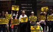 Demonstrators hold signs and chant words of gratitude outside of law firms Jenner & Block...