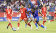 Marie-Yasmine Alidou #26 of Canada is pressured by Melchie Dumornay #6 of Haiti during the...