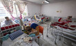 An elderly Iranian woman eats breakfast while sitting beside her bed at Kahrizak charity n...