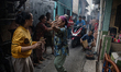 Residents dance while others grill satay in a densely populated area in Jakarta, Indonesia...