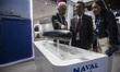 Staff explain the specifications of the Scorpene submarine using a mockup to visitors at t...