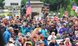 Demonstrators cheer at the Minnesota State Capitol Building while holding signs and flags...