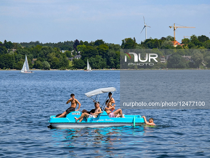 Group Of Young Men On Pedal Boat At Lake