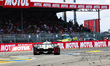 Peugeot Totalenergies #94 enters the Ford chicane as fans watch from the grandstands durin...