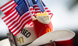A man wears a cowboy hat with U.S. President Donald Trump's mugsot, American flags, and Mc...