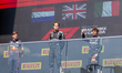 George Russell, Andrea Kimi Antonelli, and Max Verstappen stand on the podium during the F...
