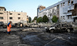 A man looks at burnt-out cars at a parking lot after a Russian drone attack in Zaporizhzhi...