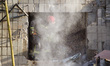A rescuer clears debris at an apartment block in the Solomianskyi district, where a sectio...