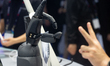 A robot hand synchronizes with a human hand at the Honor stand at the Shanghai New Interna...