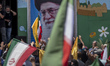Iranian worshippers hold up their hands as signs of unity with Iran's Supreme Leader, Ayat...