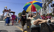 A costumed marcher poses for photos at the 2025 Coney Island Mermaid Parade in Brooklyn, N...