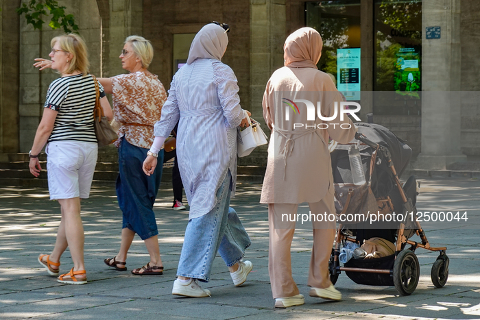 Women Walking With Baby Stroller In City Center