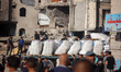 Security guards stand atop trucks carrying humanitarian aid coming in from the Zikim borde...