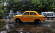 A yellow taxi moves on the street during a rainstorm in Kolkata, India, on June 27, 2025. 