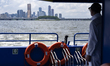 Crew members operate the Han River Bus on deck after departing from Yeouido Pier in Yeongd...