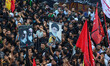 Kashmiri Shiite Muslim mourners hold portraits of Iran's Supreme Leader Ayatollah Ali Kham...