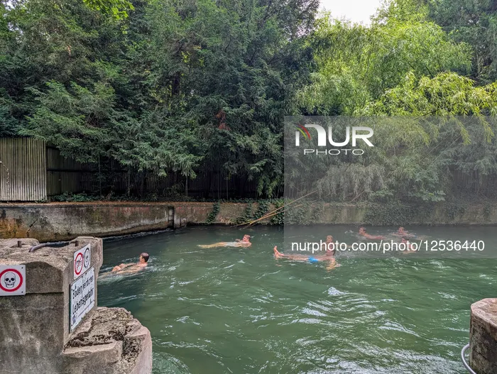 Young People Cooling Off In The Eisbach In Munich
