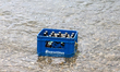 A blue beer crate with Augustiner bottles is cooled in the Eisbach stream in the English G...