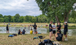 Young people meet and socialize along the stream in the English Garden in Munich, Bavaria,...