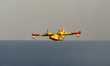 A Canadair flies above the Adriatic Sea after collecting water for wildfire suppression ne...