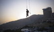 A young Iranian man hangs from a rope at Adrenaline Park in northwestern Tehran, Iran, on...