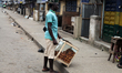 A snack seller stands in front of closed shops in Ogba as Lagos State conducts an election...