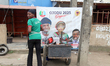 A food vendor stations her truck in front of a campaign poster in Ogba as Lagos State cond...
